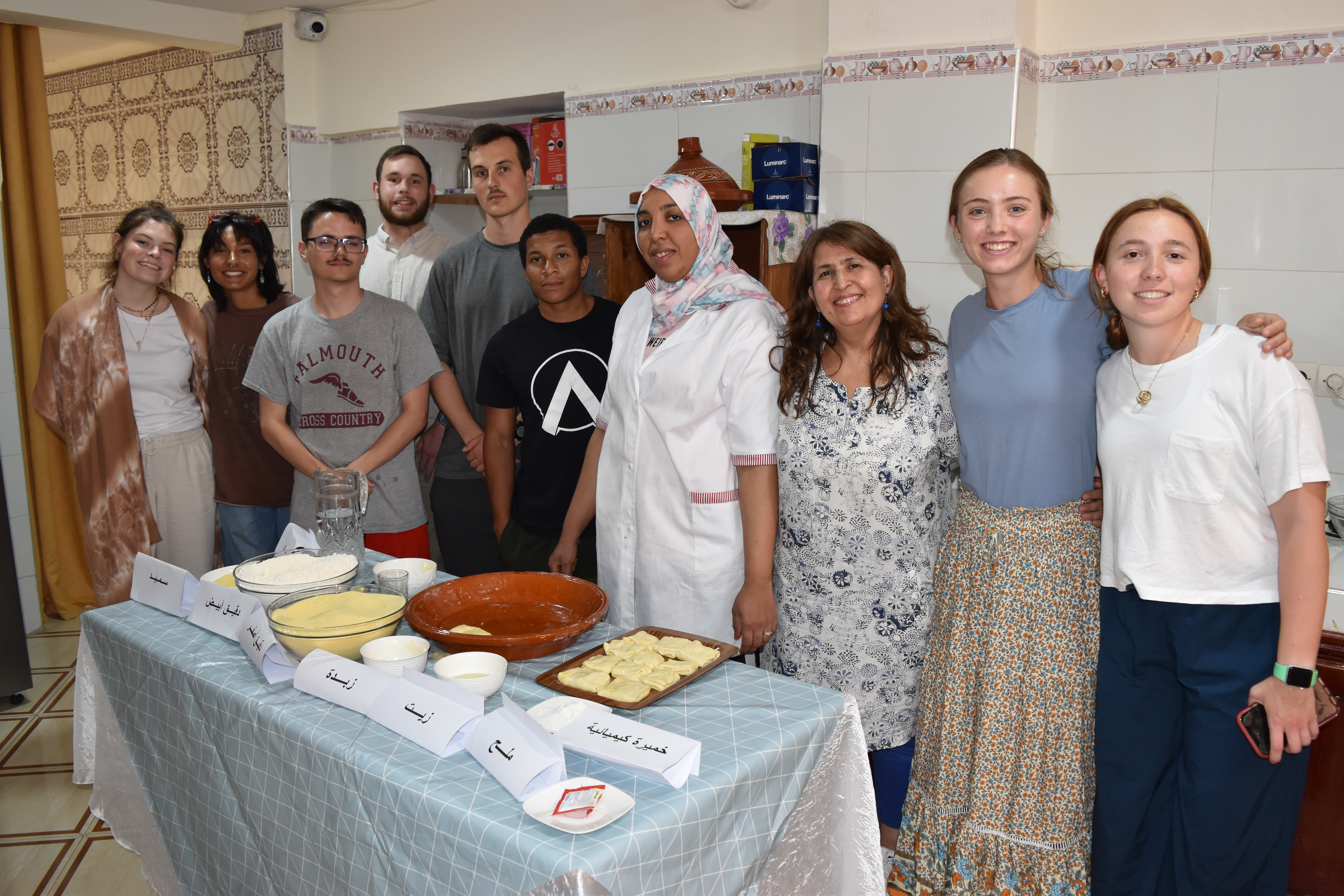 A group of students and community members in a kitchen.