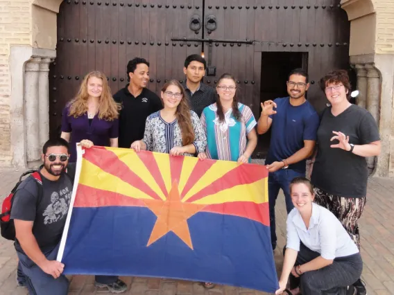 Nine Arabic Flagship Program students stand by an Arizona state flag.