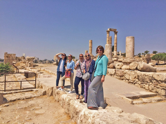 A group of people touring a citadel in Amman.