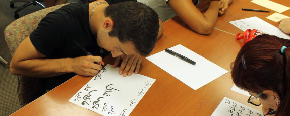 man practicing arabic writing