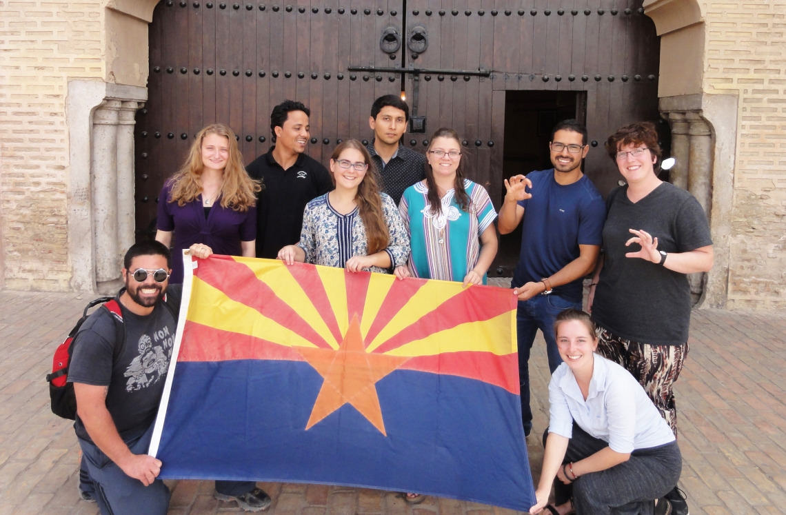 Nine Arabic Flagship Program students stand by an Arizona state flag.