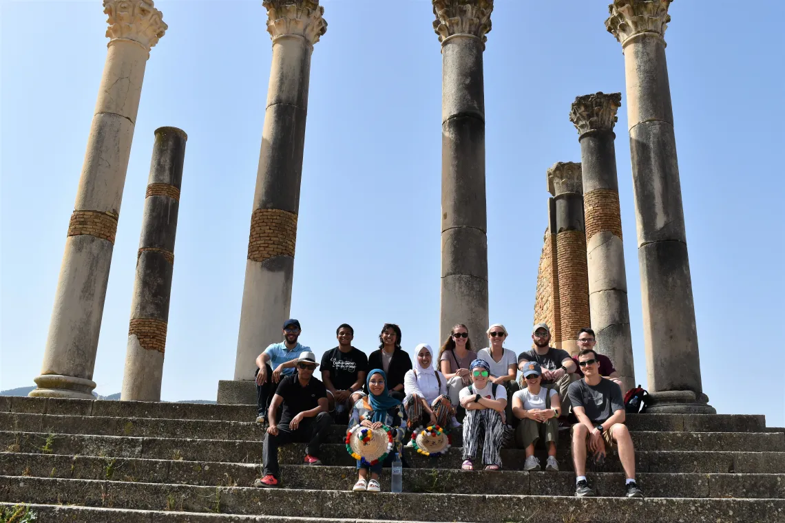 A group of students standing in front of a monument.