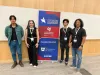 Students and Dr. MBarki standing around the QatarDebate sign