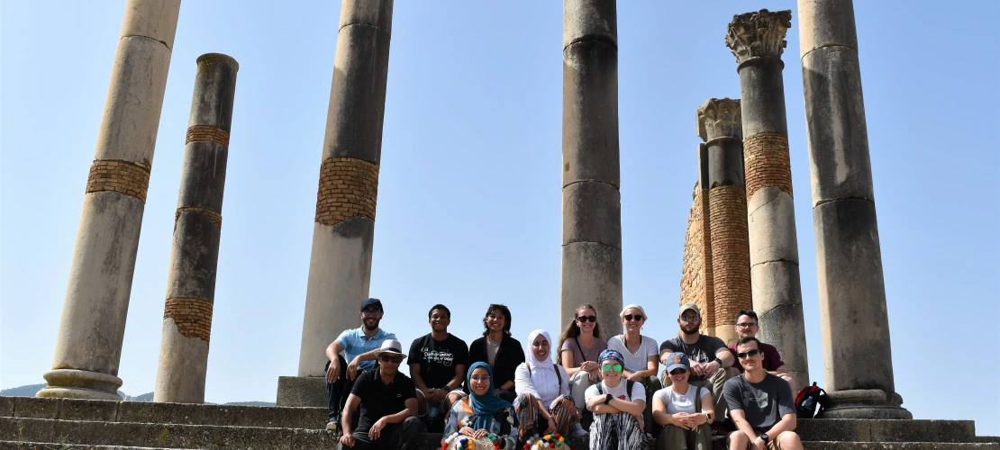 A group of students standing in front of a monument.