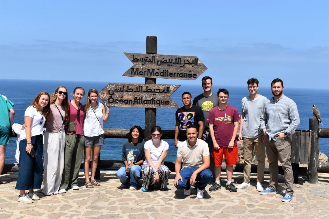 A group of students standing in front of the sea.